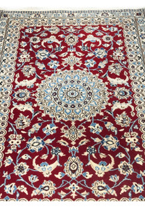 Close-up of central medallion in ivory and blue on red background