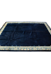 Side view of navy blue Beijing Art Deco rug with ivory floral border and wool pile
