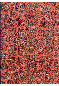 Persian Sarough rug close-up of floral sprays with navy, burgundy, gold, and ivory blossoms on a coral background, hand-knotted wool.