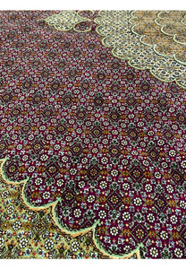 Close-up of Tabriz 50 Raj rug colors with burgundy field, ivory floral details, black outlines, and subtle blue silk highlights