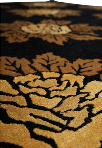 Repeating floral pattern in gold and camel on black 8x10 modern handmade wool rug