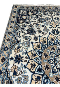 Upper edge of 2'9 x 4'10" Ivory Nain Persian Rug with ivory blossoms and navy motifs.