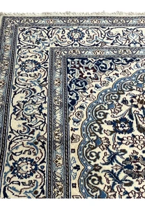 Upper edge view of Square Persian Nain Rug with ivory and navy border pattern