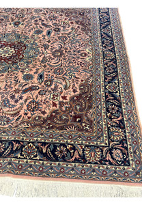 Border of Persian Tabriz rug with navy vines, salmon guard bands, and detailed floral motifs