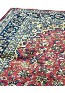 Upper edge of the rug showing navy guard borders, red field, and ivory accent florals.