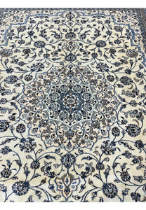 Central medallion of 10' x 13'2 Persian Nain 9LA Rug showing layered floral rosettes and symmetrical blue design.