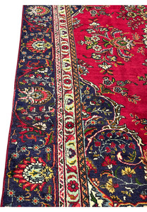 Detailed side border of 8'5" x 12'9" Persian Tabriz rug with rosettes and vines in navy and ivory