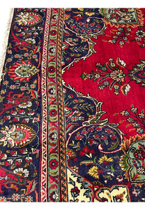 Lower edge of Persian Tabriz rug highlighting border design and fine floral weave