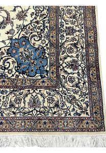 Detailed look at the border of the Persian Nain 4 LA Habibian rug featuring scrolling vines, beige and gold accents, and a thin crimson guard line.