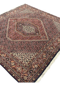 Angled view of Bijar Persian rug emphasizing its square format, layered medallion design, and luminous ivory corners framed by detailed floral borders.