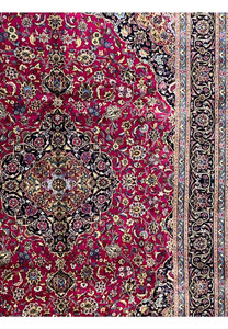 Side field detail of Mashad red rug showing floral designs and ivory highlights.