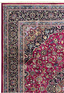 Upper border close-up of Persian Mashad rug with navy vines, sky blue accents, and floral scrolls.