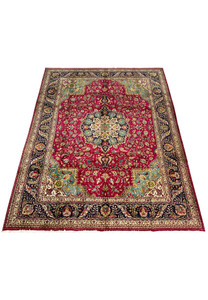 lower section of Persian Tabriz rug showing floral layout, rich red field, and multi-toned corner design