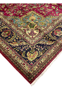 edge and fringe detail of Persian Tabriz rug with navy floral border and red outer band
