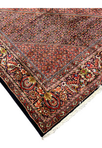 Corner view showing fringe and multicolor floral border on the Bijar Persian Iron Rug.