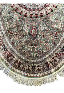 Lower portion of Persian Qum silk rug highlighting intricate green floral motifs, fine borders, and precise knot craftsmanship.