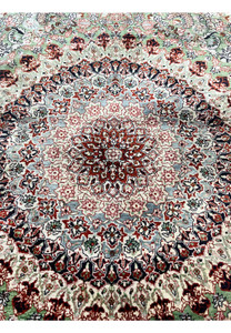 Close-up of the Qum pure silk rug medallion with detailed red, blue, and ivory floral patterns woven at approximately 600 KPSI.