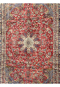 Close-up of the midfield showing the vintage Najafabad floral patterns with ruby red background and ivory vinework.