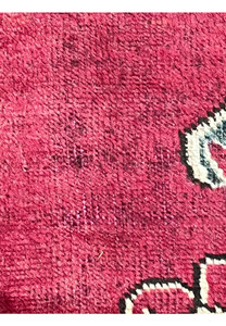 Low-pile section of patina vintage Persian Tabriz rug highlighting worn fibers, red wool field, and aged surface texture.