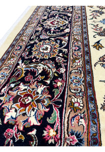 Close-up of intricate border flowers on signed Mashad Saber rug
