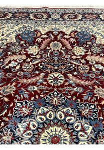 Upper section of floral Persian Isfahan rug featuring scrolling vines, palmettes, and refined color transitions on an ivory field