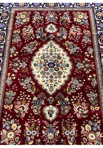 Midfield detail of Persian Isfahan rug highlighting ivory medallion and silk floral accents