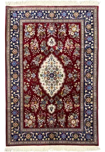 Full view of Persian Isfahan wool and silk rug with burgundy field, ivory medallion, and navy floral border