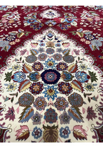 Inner medallion detail of Persian Isfahan rug with symmetrical floral design and silk accents
