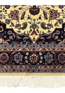 Lower border detail of Persian Tabriz rug with repeating floral rosettes on navy groun