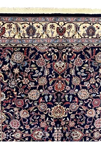 Upper border detail of Persian Sarough rug showing ivory ground with repeating floral motifs