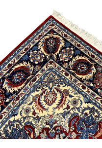 Corner detail of Persian Tabriz rug showing navy border motifs, ivory corner spandrel, and crisp burgundy field pattern