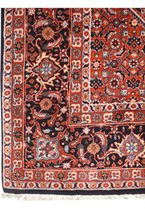 Detailed view of Bijar Persian iron rug border with repeating floral motifs on dark navy background