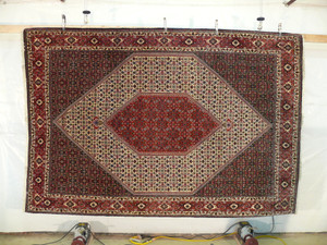 Persian Bijar rug hanging view showing geometric medallion and detailed border work
