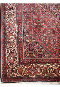 Persian Bijar rug border featuring floral motifs in red, ivory, and dark navy