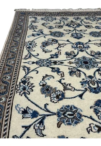 Color detail of Persian Nain rug highlighting ivory wool and layered blue floral tones