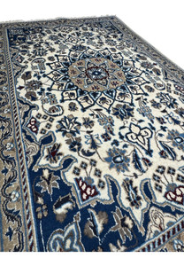 Angled perspective highlighting wool pile texture and detailed medallion of Persian Nain rug