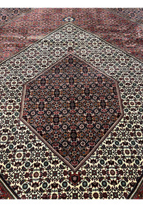 Close view of the diamond medallion with ivory ground and fine geometric detailing in a Persian Bijar rug