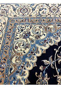 Inner border detail of Persian Nain silk rug displaying light blue vines, ivory ground, and tightly woven floral patterns with crisp definition