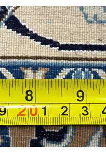 Measured backside of a Persian Nain 6 LA rug showing knot density, ruler scale, and precise hand-knotting with silk and wool materials