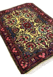 Angled view of Persian Bijar floral rug emphasizing heavy construction, deep red borders, golden field, and durable hand knotted wool surface