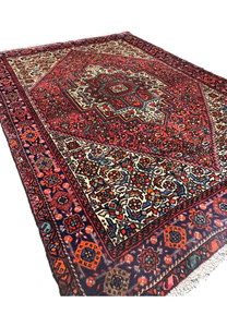 Angled perspective of a Persian Gholtogh rug showing pile height, geometric medallion depth, color contrast, and overall structure of the hand-knotted wool