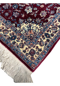 Edge view of a Persian Tabriz rug showing even finishing, crisp borders, tight weave structure, and consistent color definition along the rug perimeter