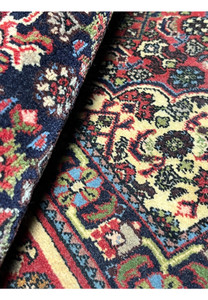 Rolled view of a Persian Bijar rug highlighting weight, flexibility, dense wool pile, and the solid construction associated with iron rugs