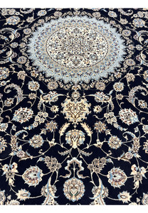 Lower field detail of Persian Nain Habibian silk rug showing scrolling floral motifs, silk sheen, and crisp contrast against navy background