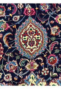 Detailed Persian Mashad rug motif featuring floral medallion elements, intricate curvilinear vines, and silk highlights on a deep navy background