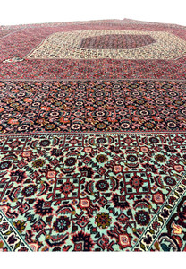 Detailed view of geometric motifs on a Persian Bijar iron rug with layered diamond patterns, rich red and navy palette, and exceptionally durable wool pile