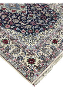 Side edge view of a Persian Isfahan rug showing clean selvedge, tight knot structure, and rich navy, ivory, and burgundy color palette