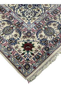 Angled side view of a Persian Isfahan rug emphasizing the plush wool pile, silk accents, navy ground, and finely articulated floral design