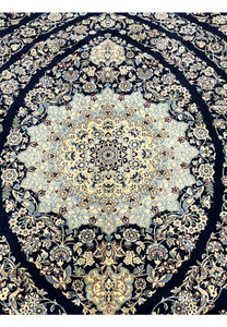 Detailed medallion of a Persian Nain 6 La rug with intricate floral motifs woven in silk and kork wool on a navy background