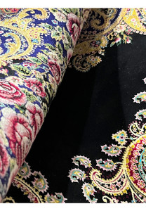 Zoomed rolled detail of a signed Persian Qum pure silk rug highlighting fine pile and dense knot structure